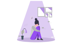 A person sits sadly in a purple room.
