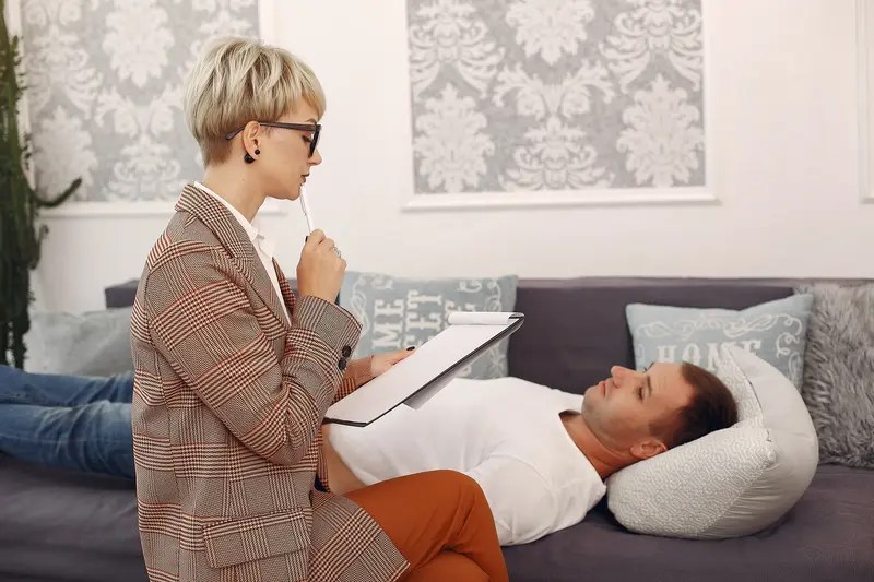 Man sitting psychologist in office talking about problems