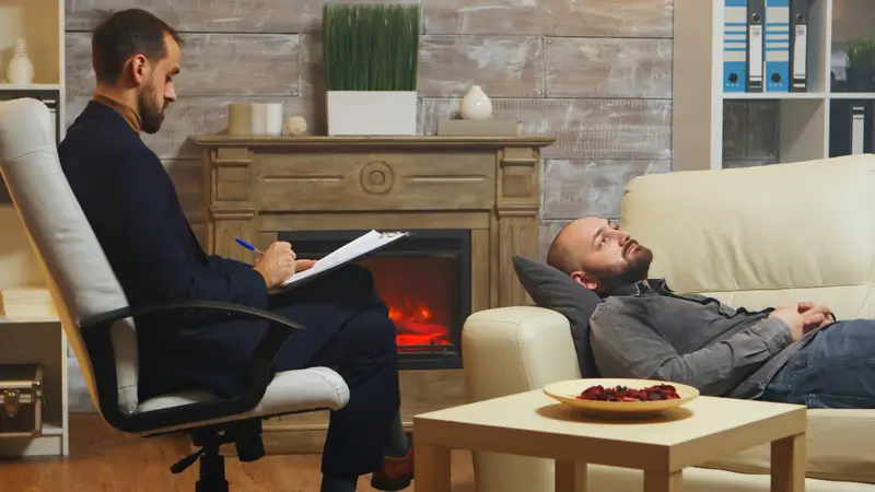 bearded man laying down on couch at prolonged exposure therapy