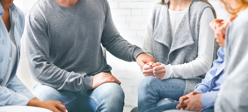 Depressed addicted woman sharing her problems on a group meeting