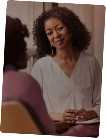 Two people have a pleasant conversation in an indoor setting.