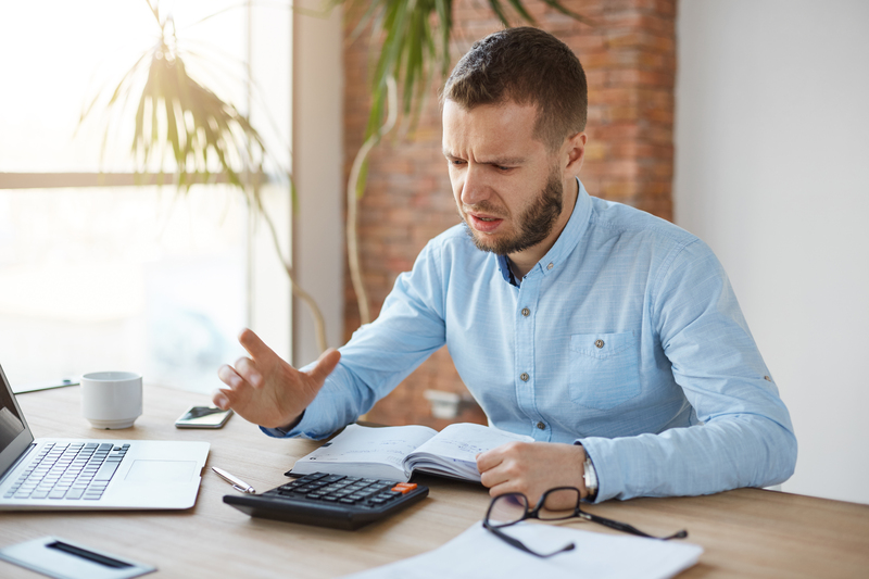 Portrait unhappy mature bearded accountant working company office doing taxes